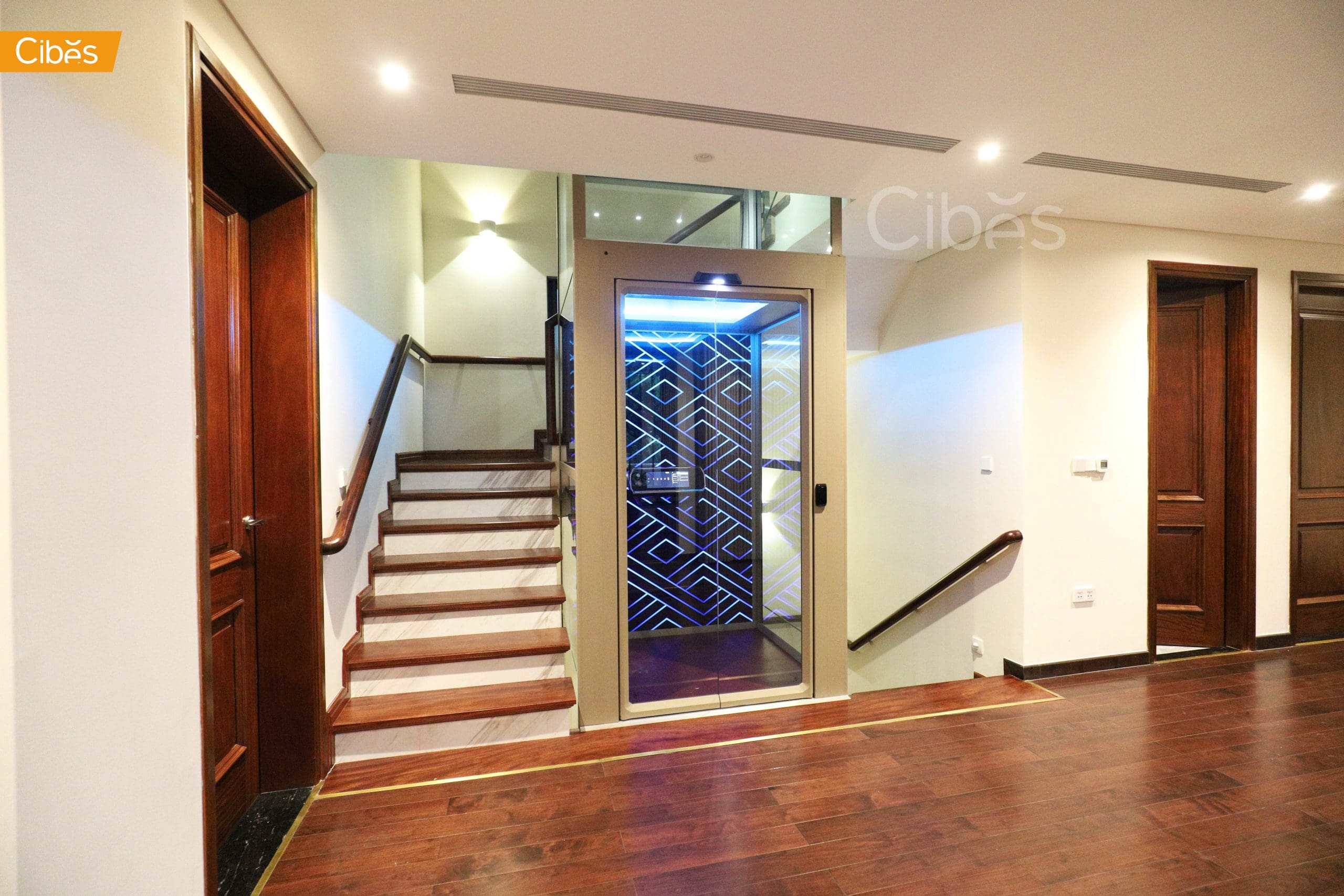 A modern Cibes home lift with sleek glass panels installed in a residential living room.