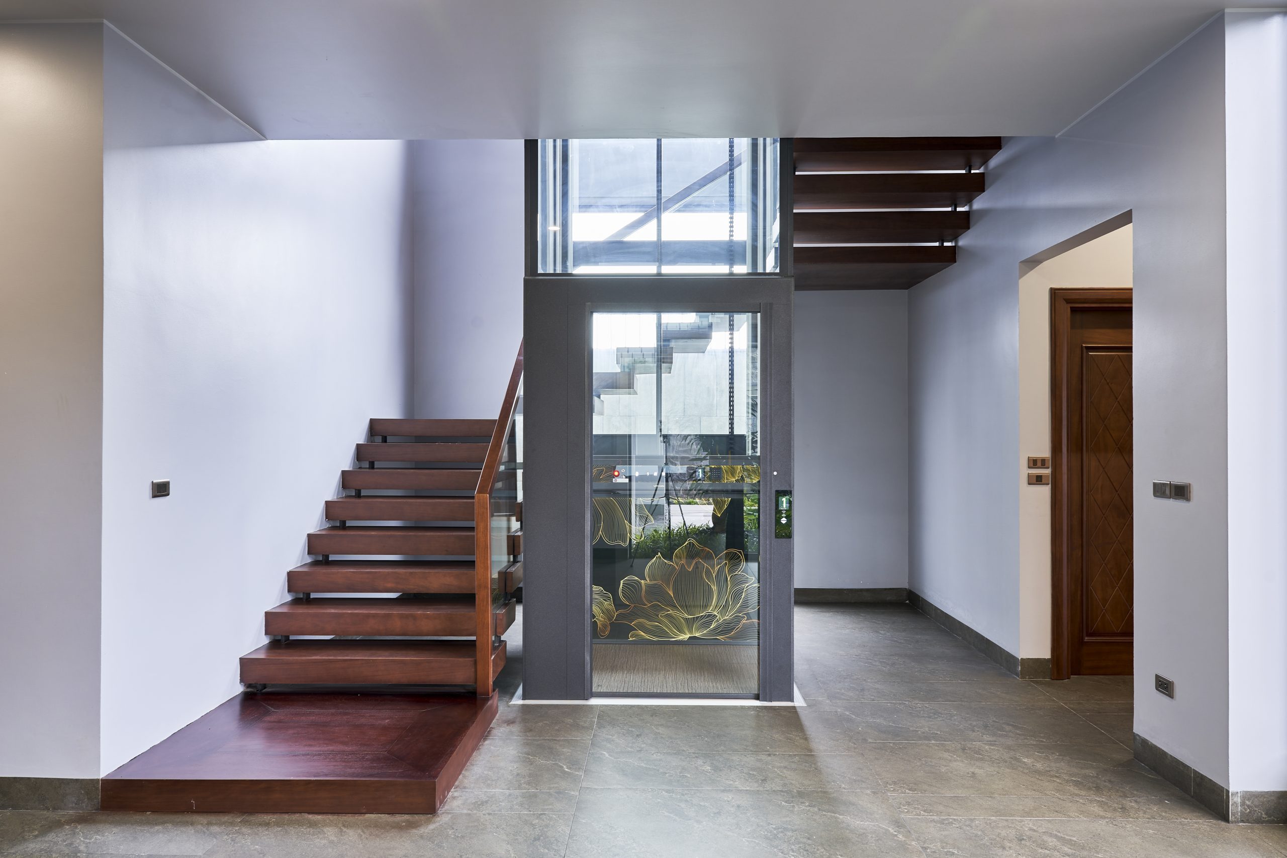 Luxury black Cibes V80 Aurora elevator integrated into the center of a modern staircase