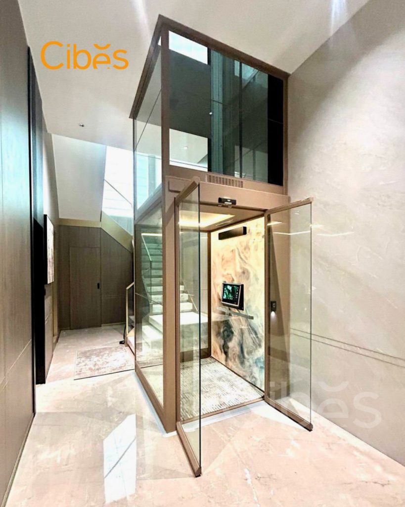Screw-driven lift installed in a Cambodian villa with glass shaft and compact home lift design.
