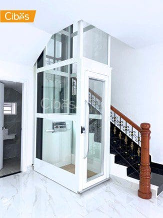 Screw-driven residential elevator installed on finished floor without pit.